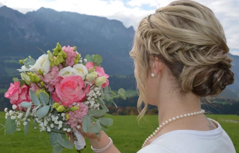 Mann und Frau unter einem Schirm auf einer Hochzeit im Freien