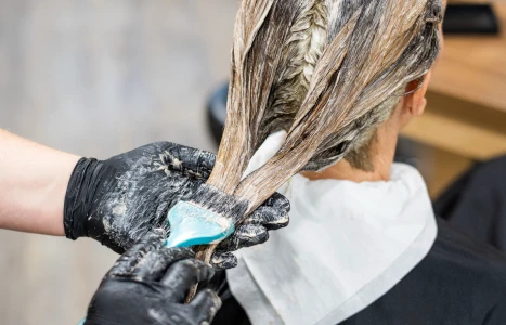 Langes braunes glattes Haar im Studio vor einem trockengewachsenen Blumenstrauß